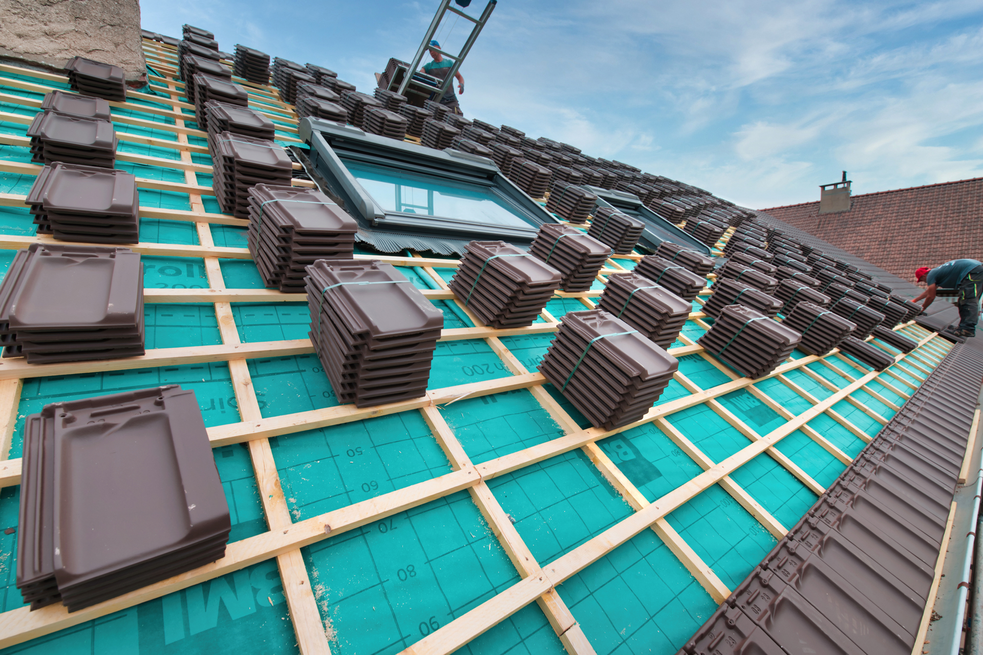 Professionnel posant des tuiles sur une toiture