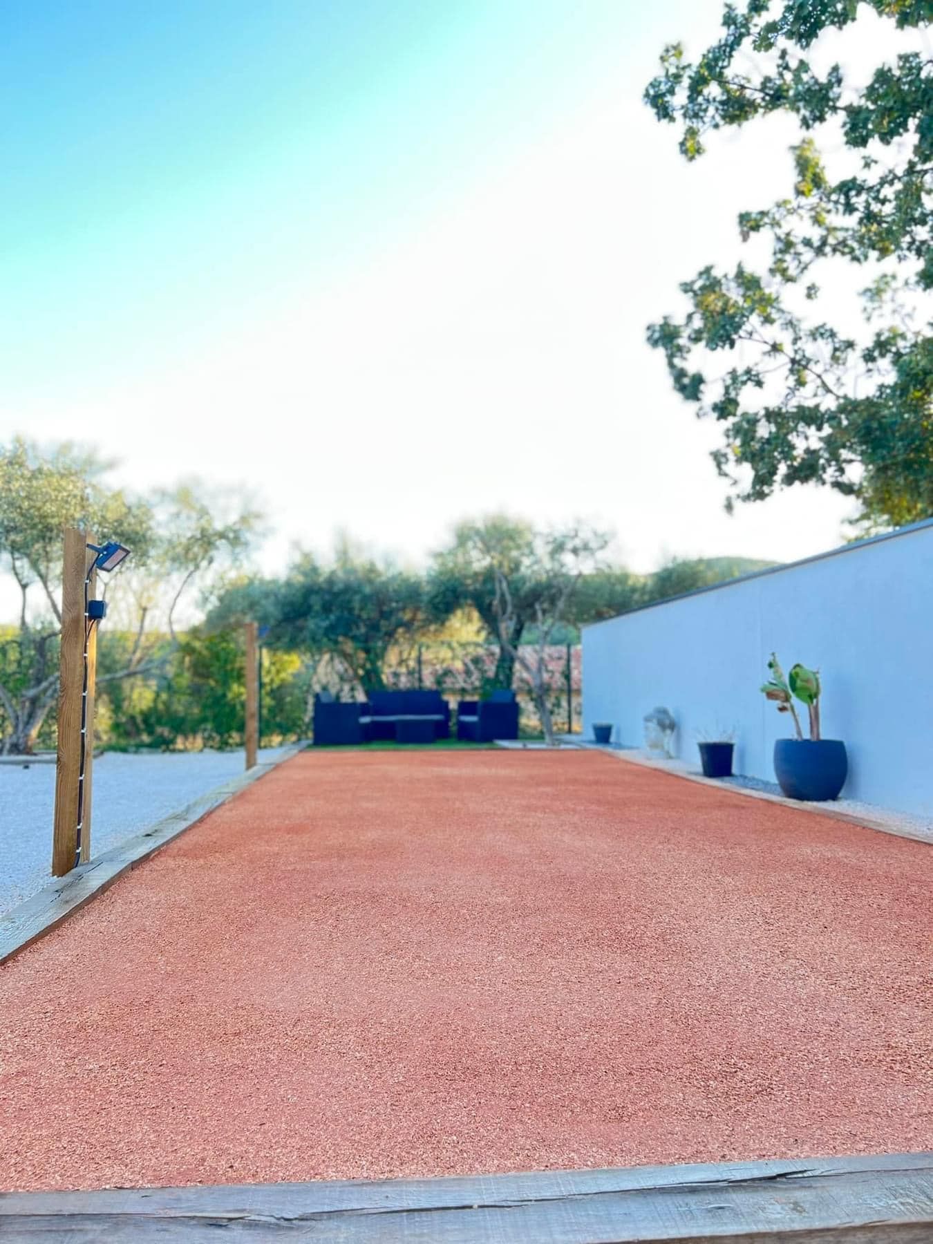 Un terrain de boules et des canapés contre un mur blanc