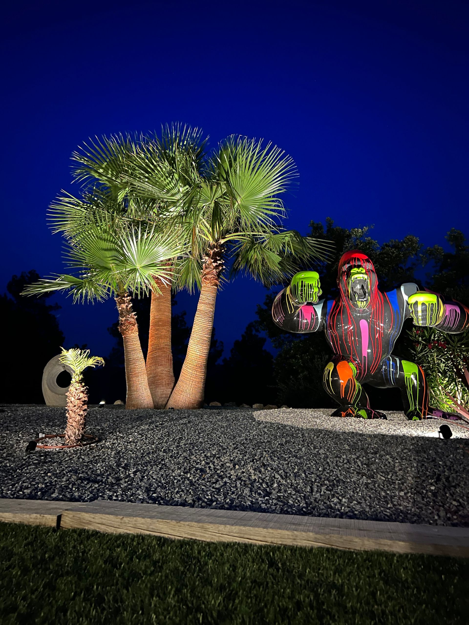 Palmiers et statue de gorille illuminés