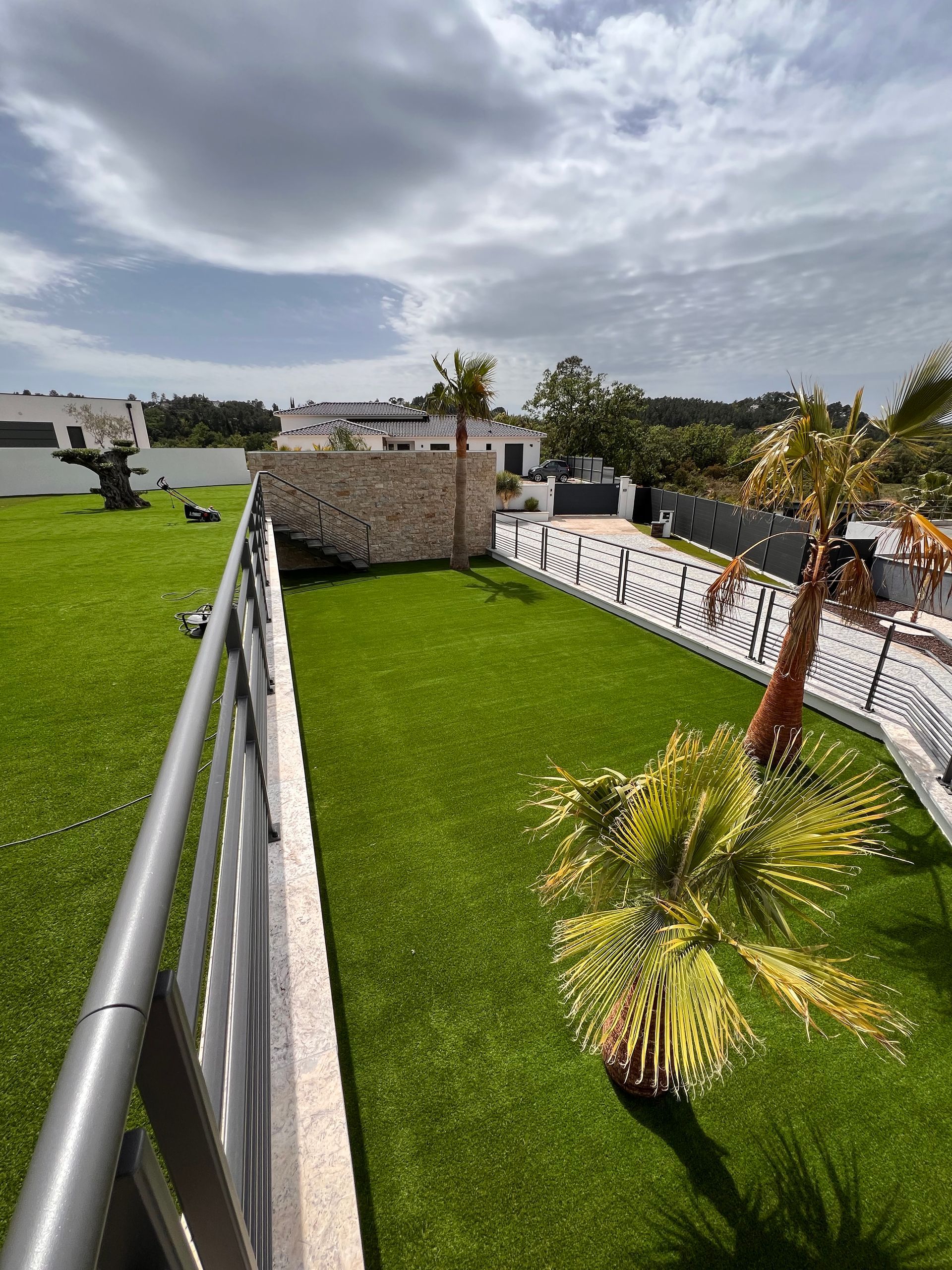 Un jardin-terrasse en gazon artificiel avec des palmiers