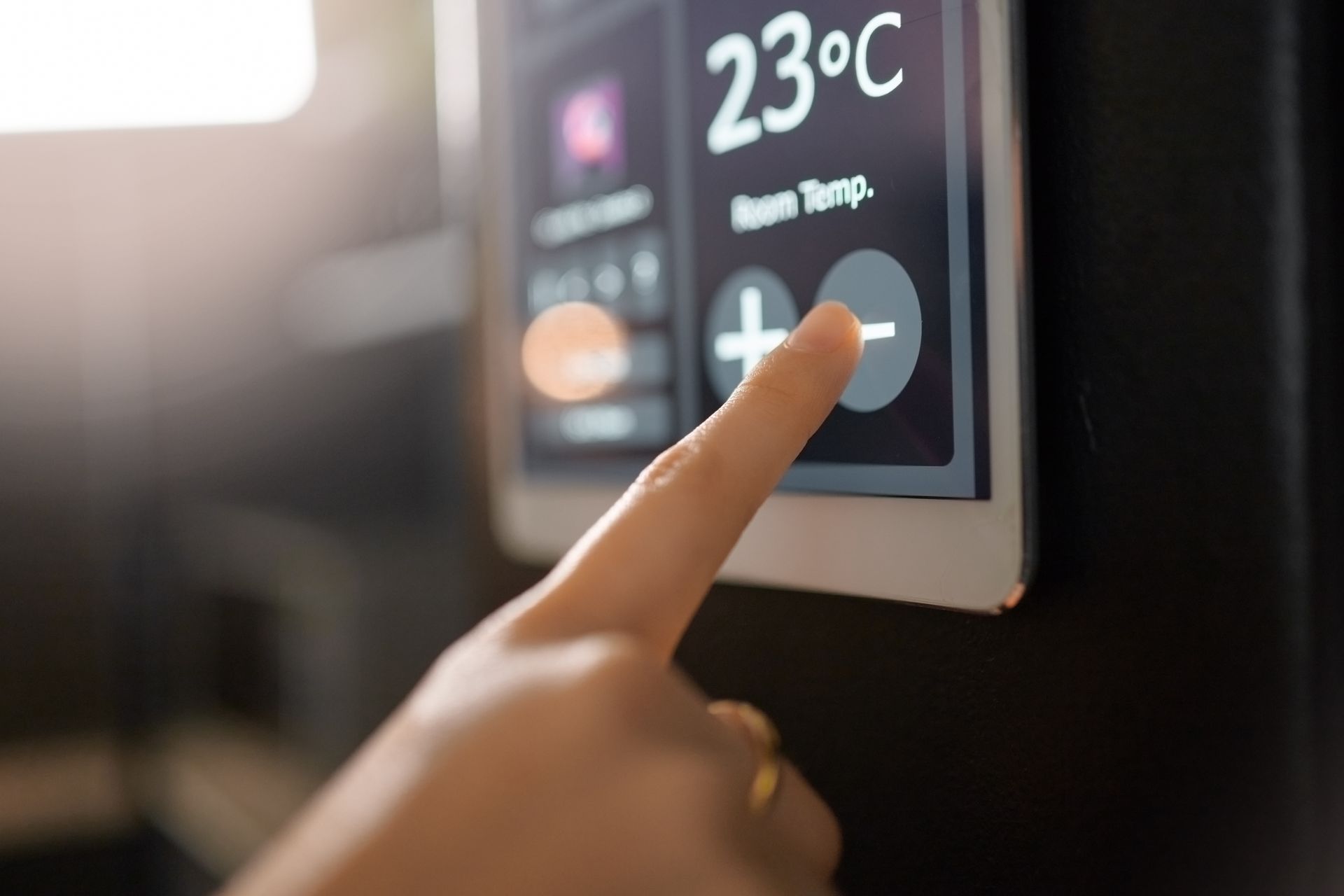 Une personne appuie sur un thermostat tactile.