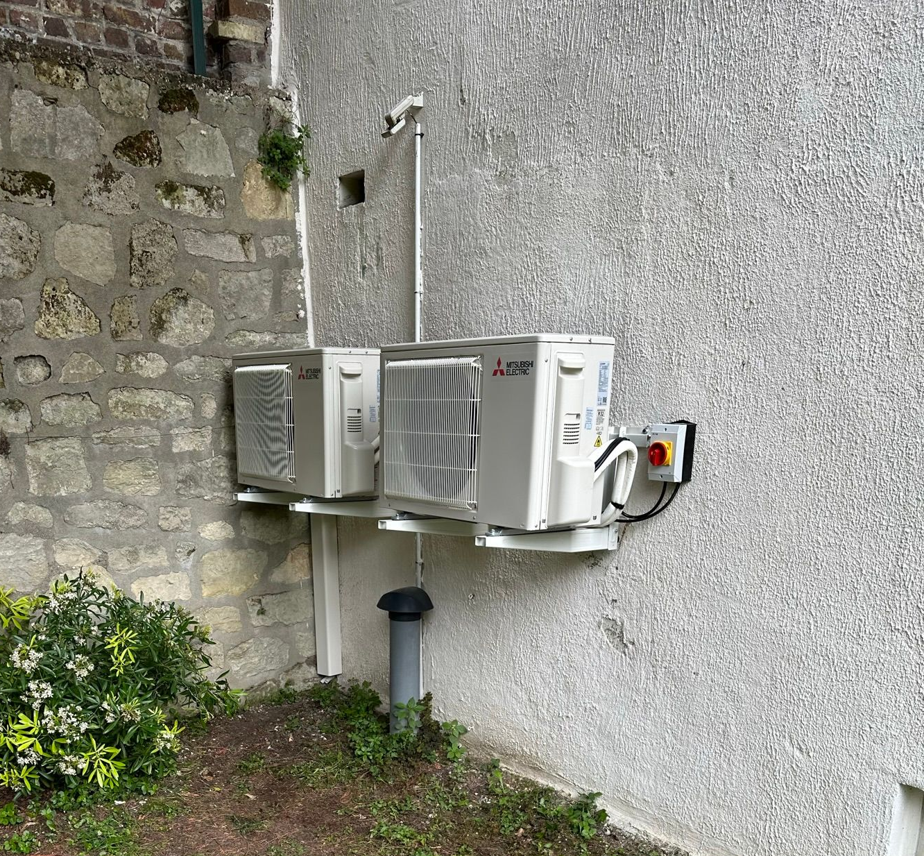 Deux unités de climatisation murales fixées à un mur extérieur.