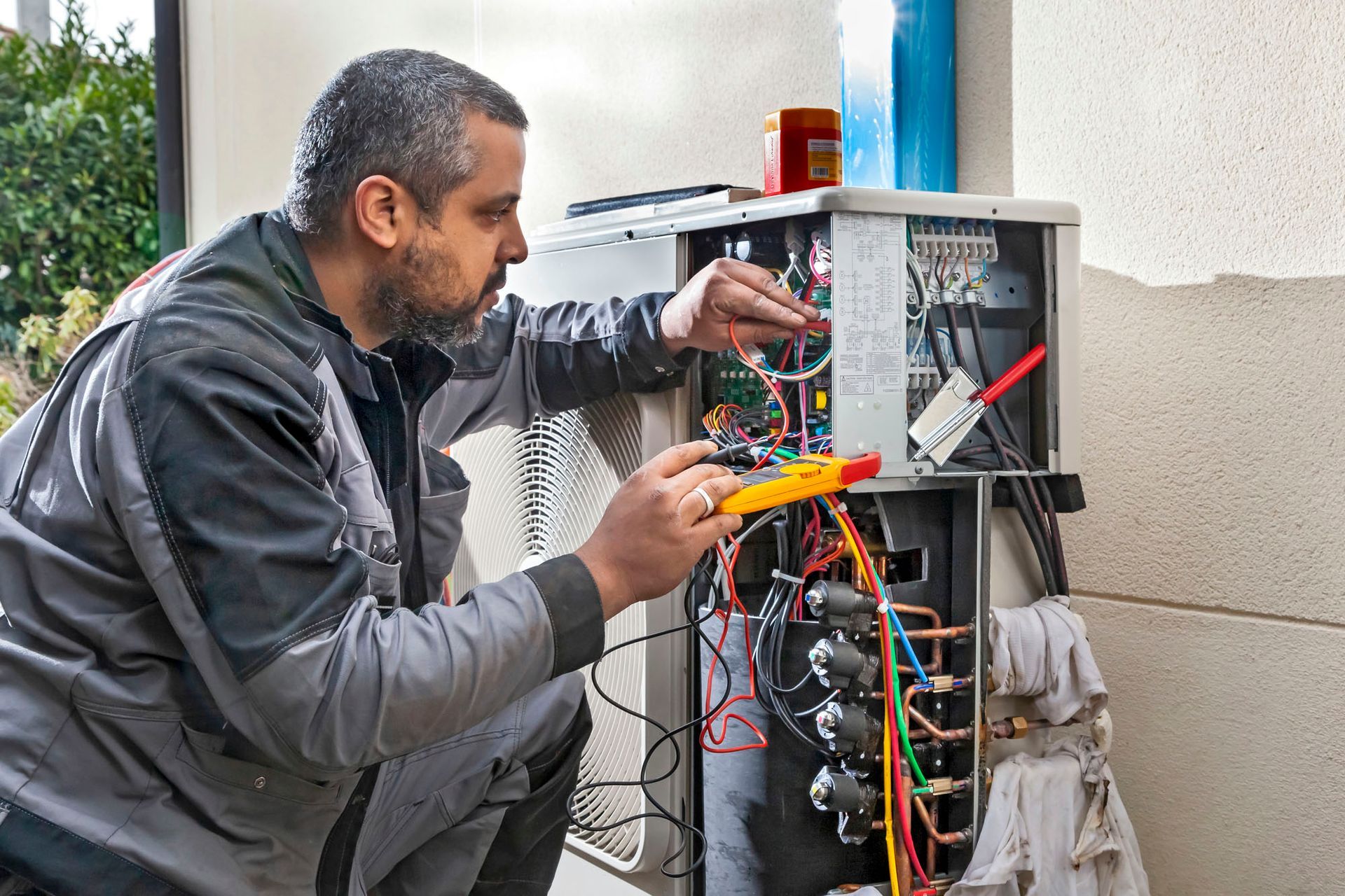Un technicien examine le câblage électrique d'une pompe à chaleur.