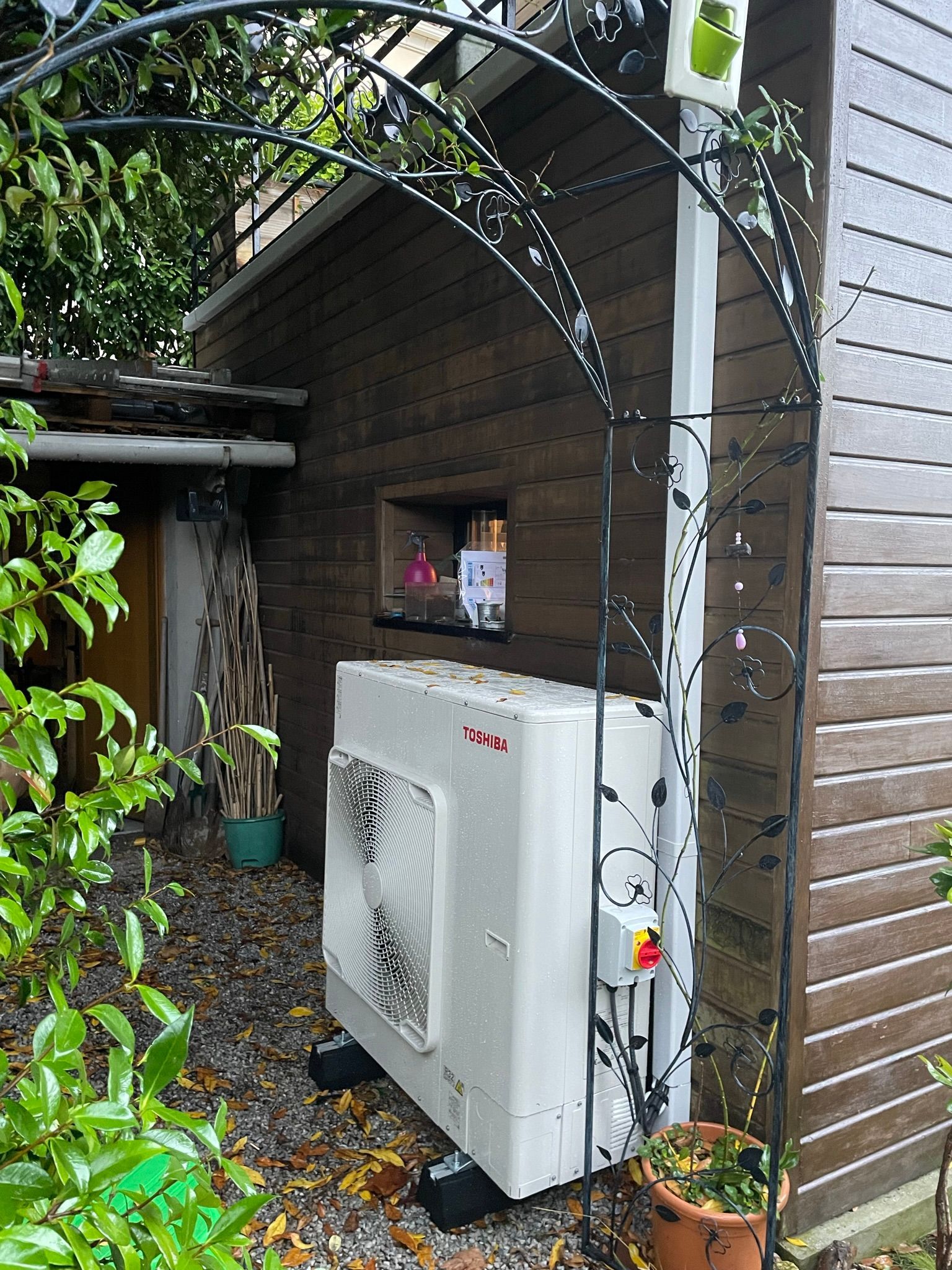Unité de pompe à chaleur à côté d'un bâtiment en bois.