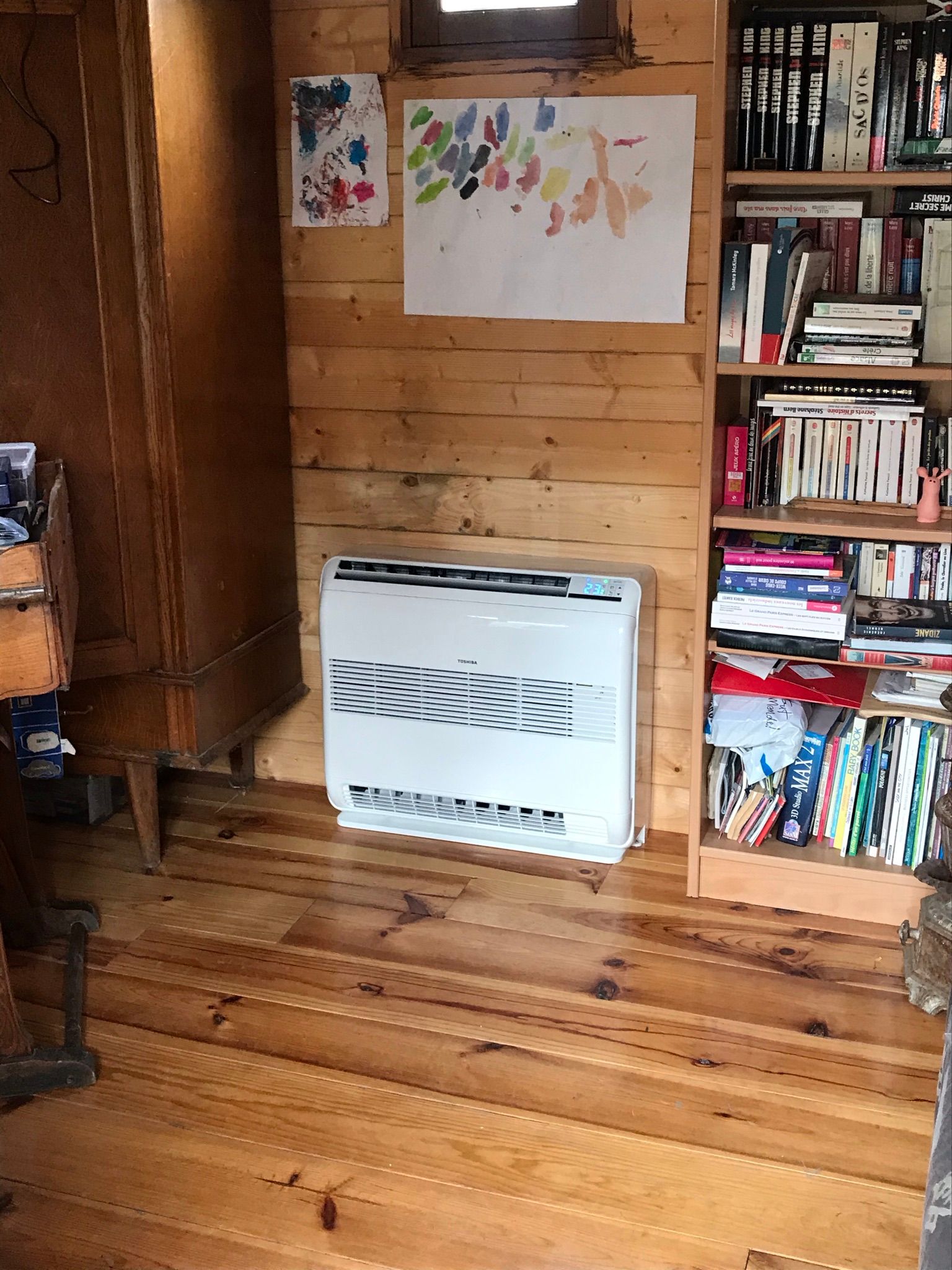 Intérieur aux murs en bois avec une climatisation, des étagères et un parquet.