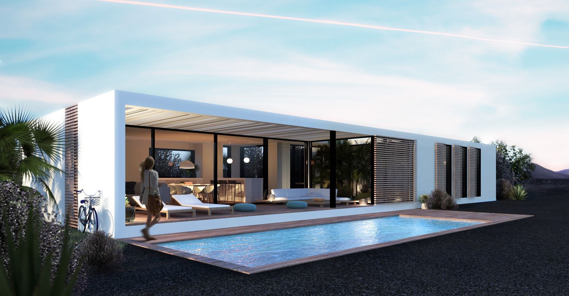 Moderna casa rectangular blanca con piscina, paredes de vidrio y una mujer caminando afuera.