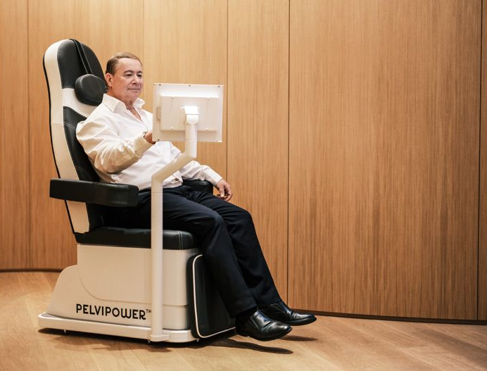 Eine Person sitzt in einem holzgetäfelten Raum auf einem PelviPower-Stuhl für Beckenbodentraining.