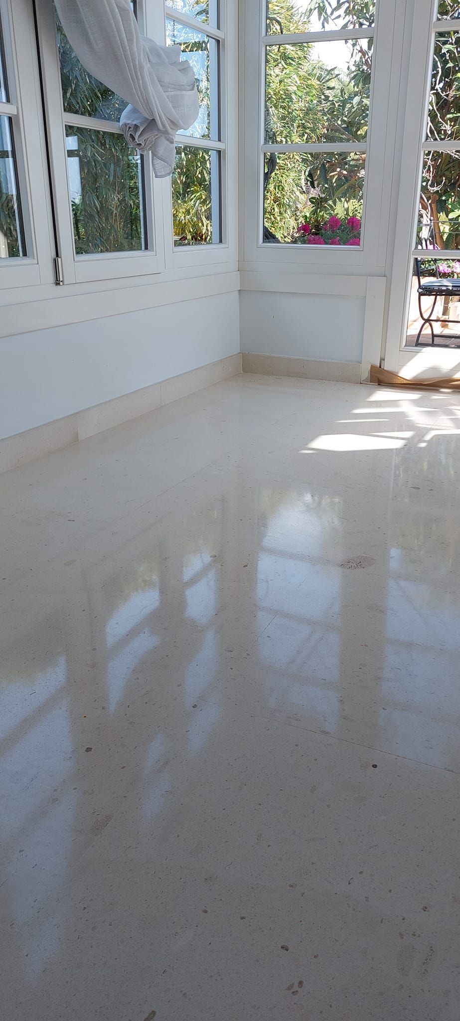 Una habitación con muchas ventanas y suelo de mármol.