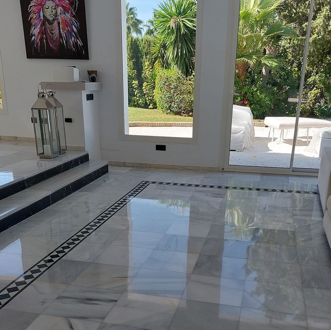 Una sala de estar con una linterna en el suelo y un cuadro en la pared.