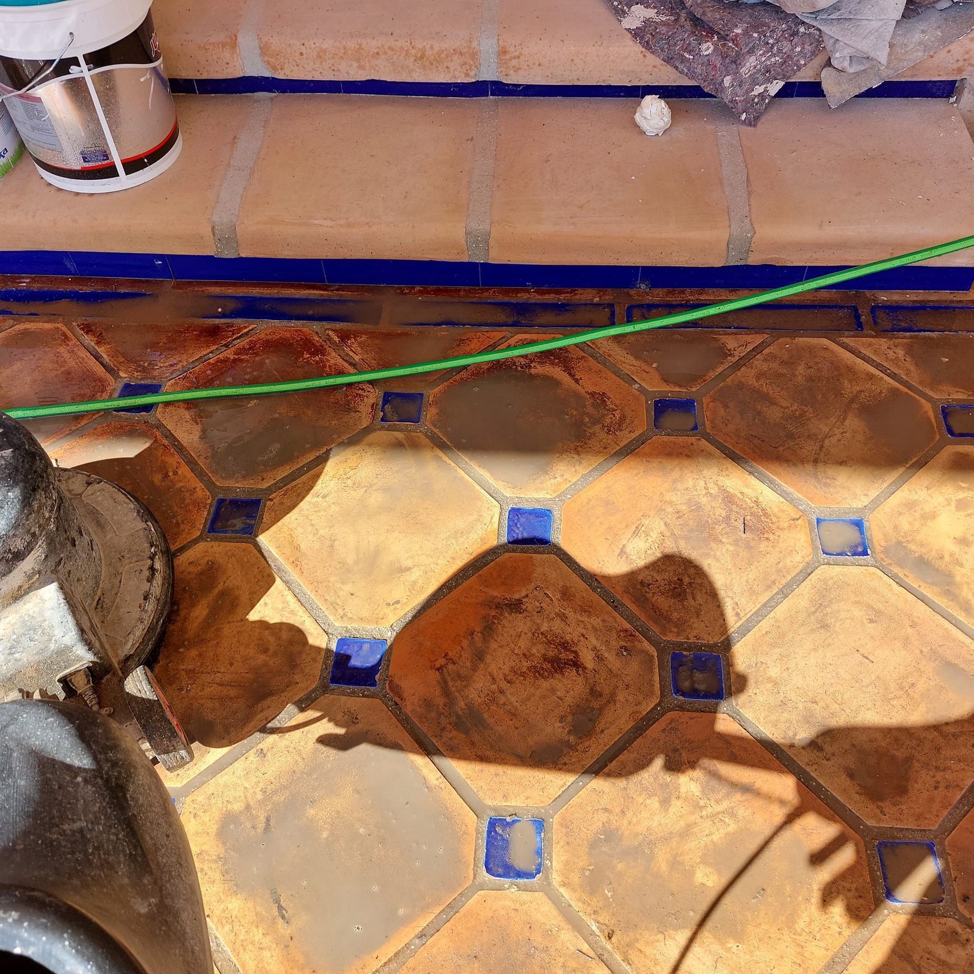 La sombra de una persona se proyecta sobre un suelo de baldosas.