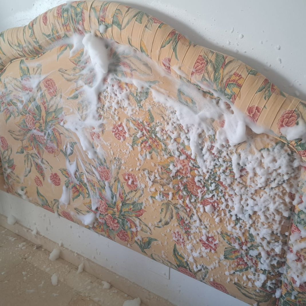 Un sofá con estampado floral está cubierto de espuma.