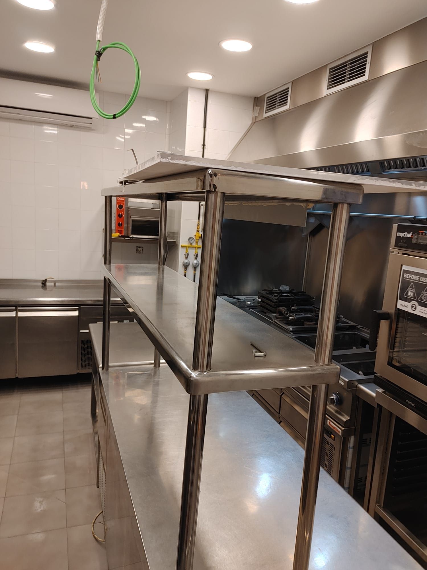 Una cocina con electrodomésticos y estantes de acero inoxidable.