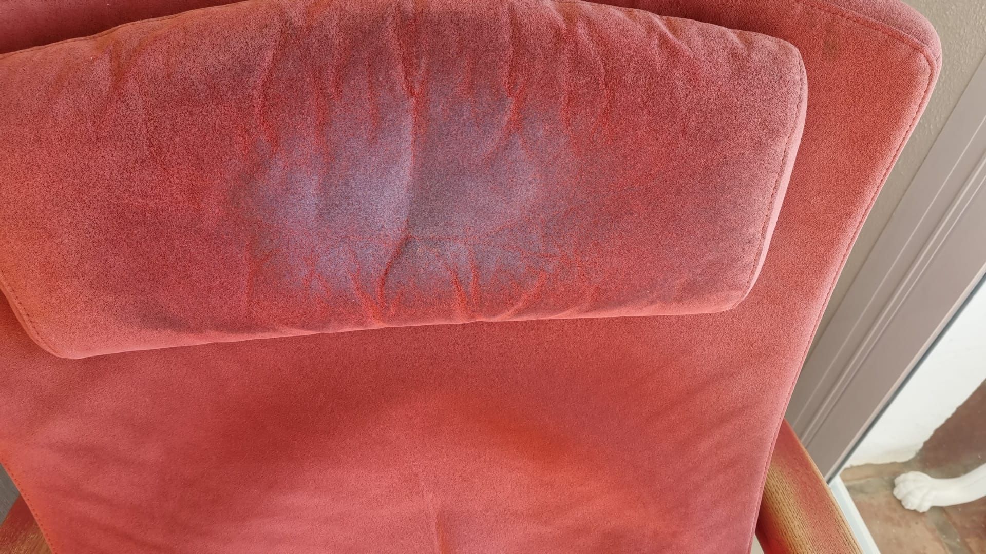Un primer plano de una silla roja con una almohada encima.