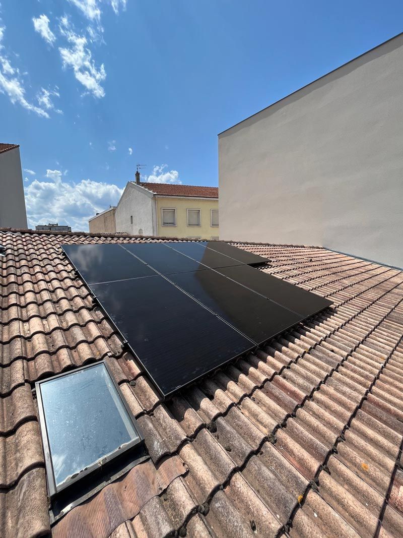 Des panneaux solaires installés sur un toit de tuiles sous un ciel bleu