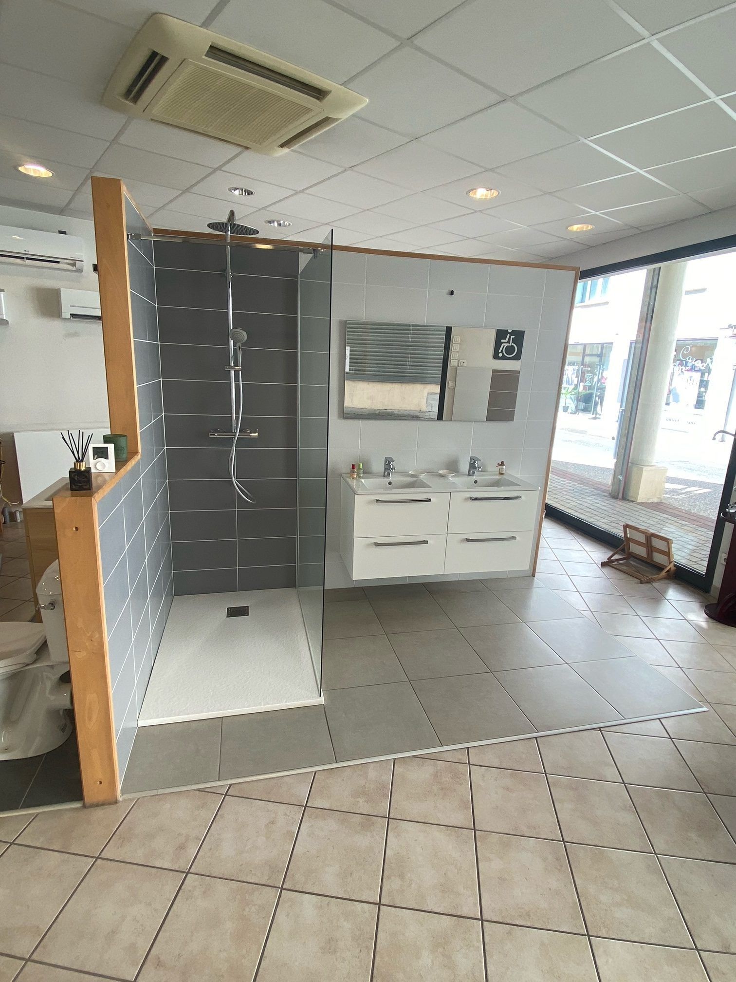 Salle de bains moderne avec douche carrelée grise, meuble-lavabo blanc et grande entrée vitrée