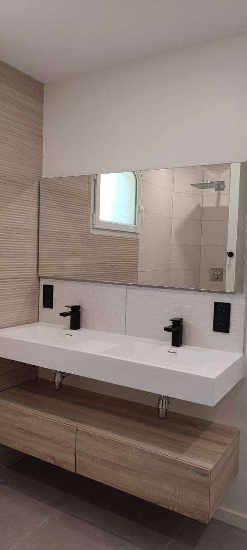 Meuble-lavabo moderne avec double vasque, grand miroir et armoires en bois aux tons neutres