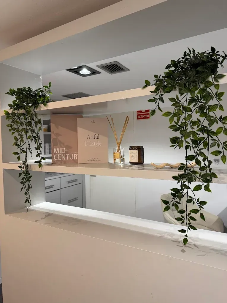 Mostrador de recepción moderno con plantas colgantes verdes, decoración en tonos beige 