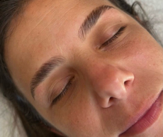 Primer plano de una persona con los ojos cerrados, mostrando las cejas, la nariz y los labios sobre un fondo neutro.