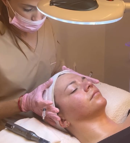 Tratamiento facial en curso: una esteticista con guantes aplica un dispositivo