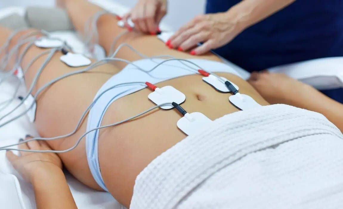 Brazos con electrodos médicos adhesivos y cables azules conectados para un procedimiento de tratamiento o monitorización.