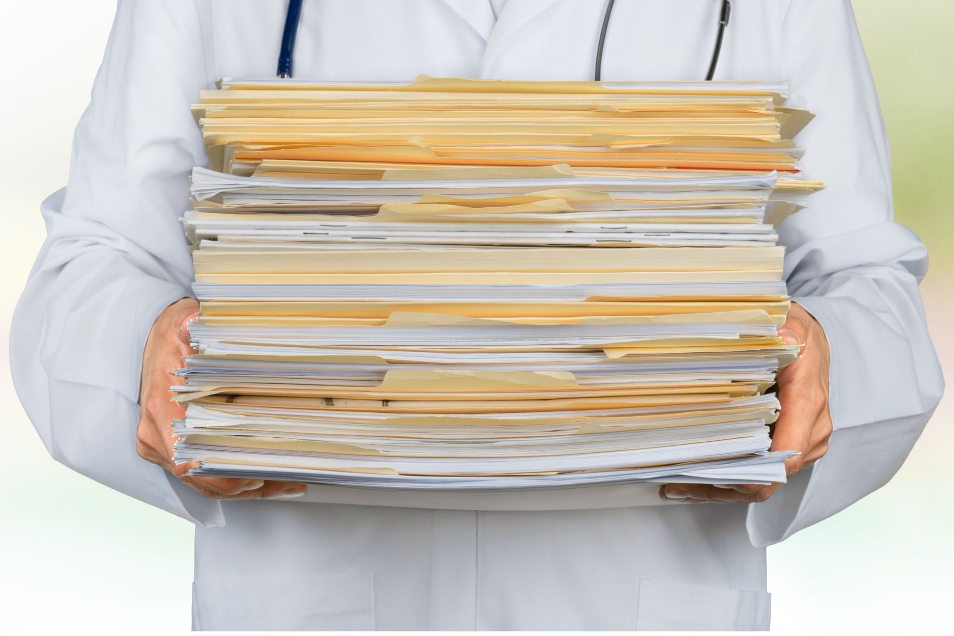 Un médico sostiene una pila de papeles en sus manos.