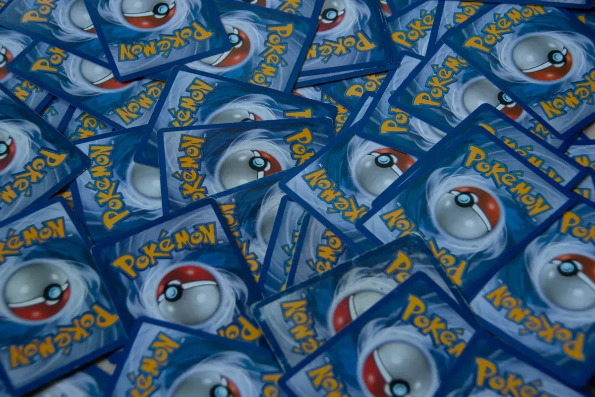 Pila de cartas coleccionables de Pokémon azules, con reversos de Poké Ball y logotipos amarillos de Pokémon.