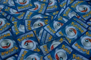 Pila de cartas coleccionables de Pokémon azules, con reversos de Poké Ball y logotipos amarillos de Pokémon.