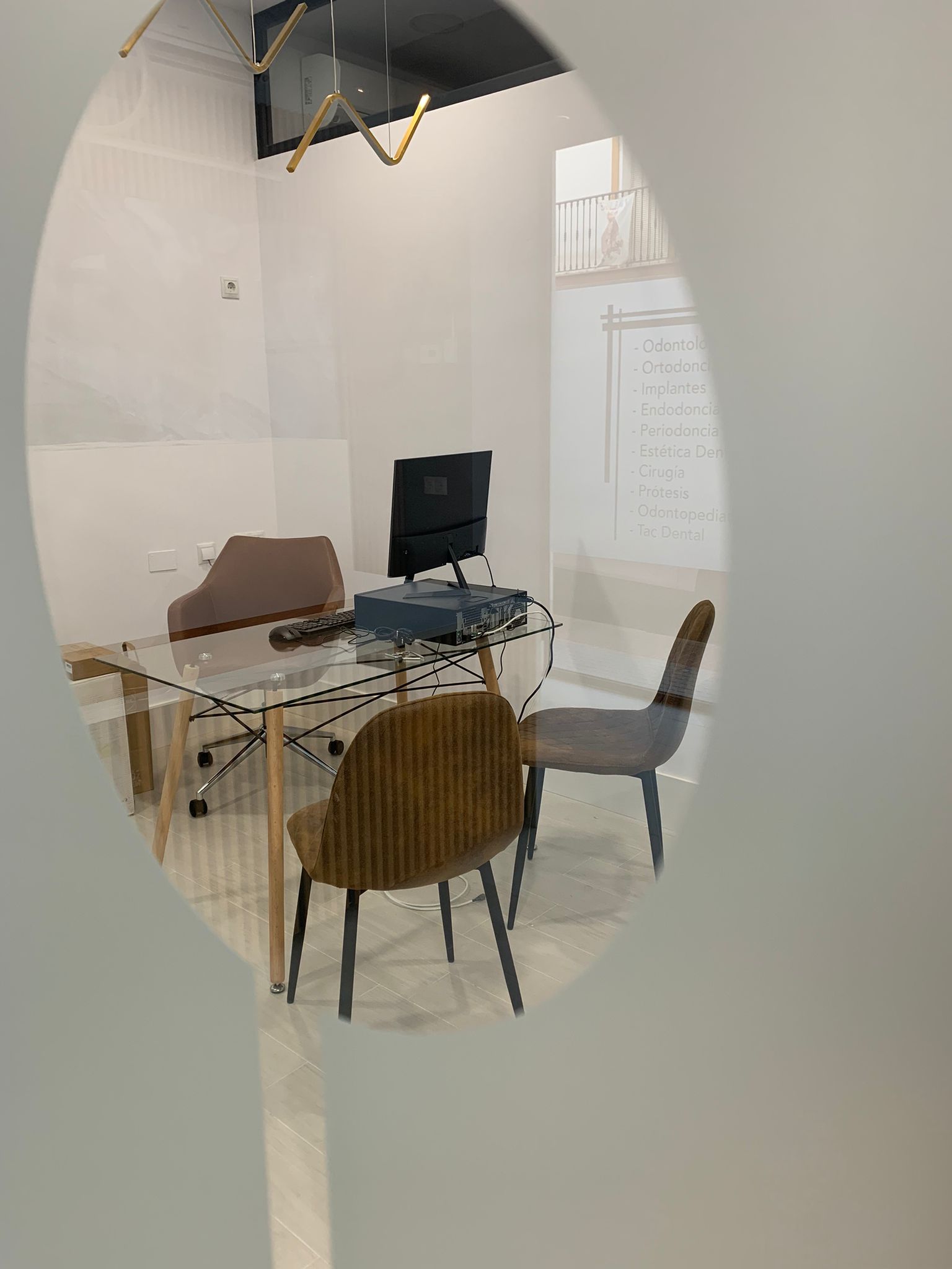 Una habitación con una mesa y sillas y una computadora encima.