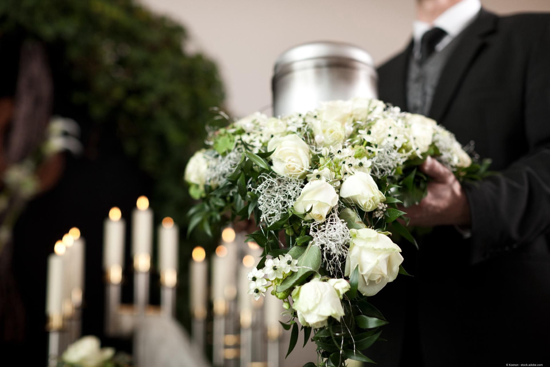 Person hält Urne mit Blumen – Symbol für würdevolle Abschiednahme