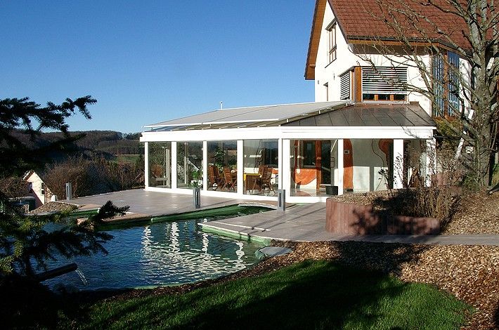 großes Haus mit Wasser und Wintergarten