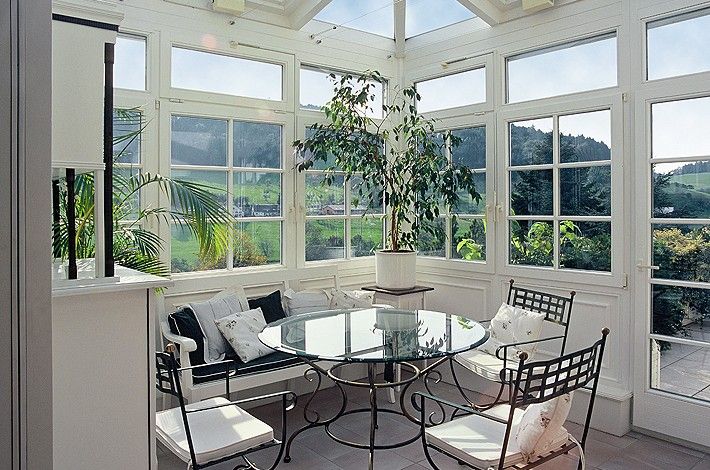 heller und freundlicher Wintergarten von Innen mit Holz-Garnitur