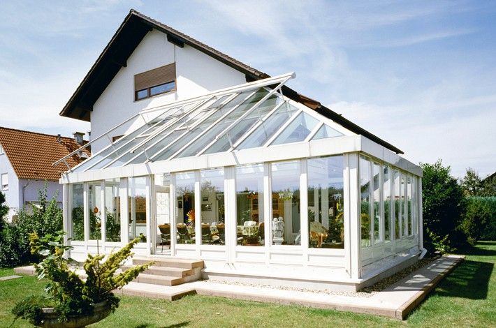 Heller Glaswintergarten mit Blick in den grünen Garten