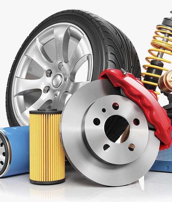 Un grupo de piezas de automóvil que incluye un neumático, un disco de freno, un amortiguador y un filtro de aceite.