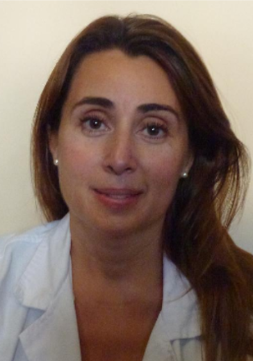 Una mujer con una bata de laboratorio blanca sonríe para la cámara.