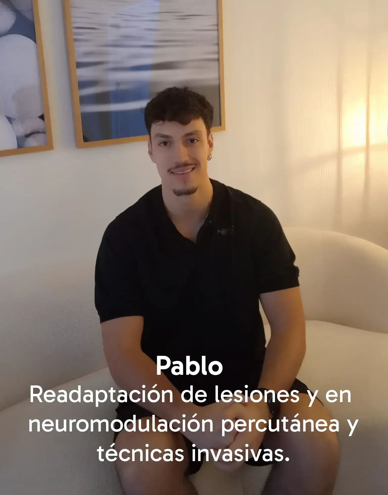 María Miquel Casares, psicóloga, está sentada sonriendo en un sofá color crema en una habitación con obras de arte.