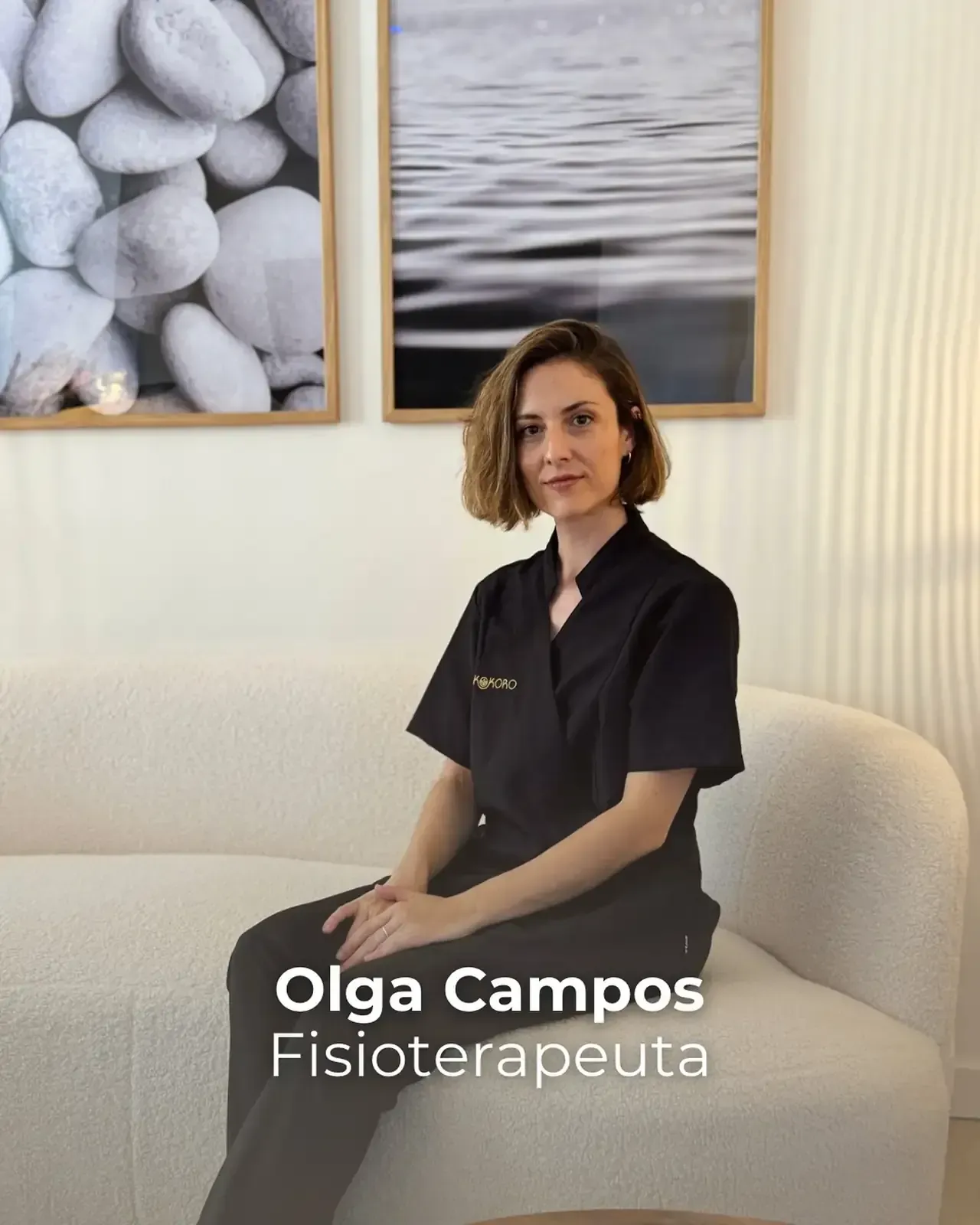 Mujer con uniforme médico negro sentada en un sofá, debajo de dos fotografías enmarcadas;Olga Campos, Fisioterapeuta.
