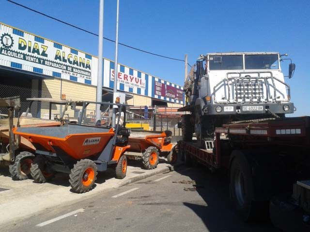 Una fila de camiones están estacionados frente a un edificio que dice Díaz Alcara.