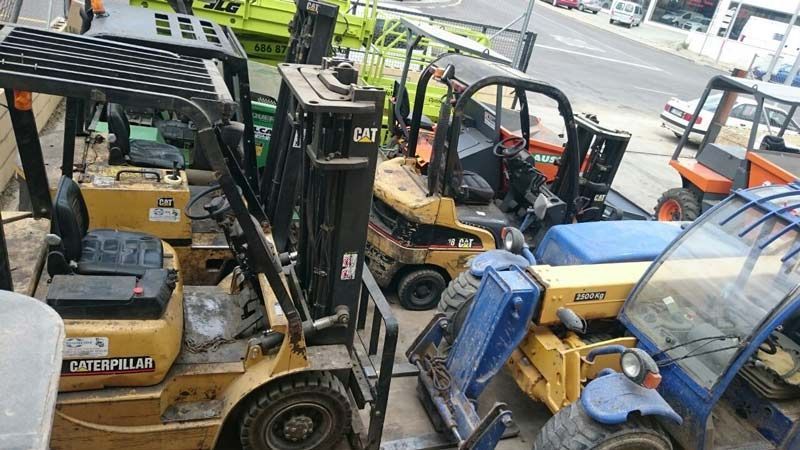 Un montón de carretillas elevadoras están estacionadas en un estacionamiento.