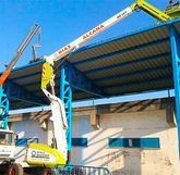 Una grúa está trabajando en el tejado de un edificio.