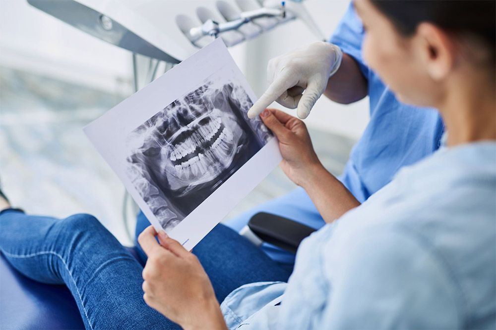 Dentista y paciente revisando una radiografía dental en una clínica
