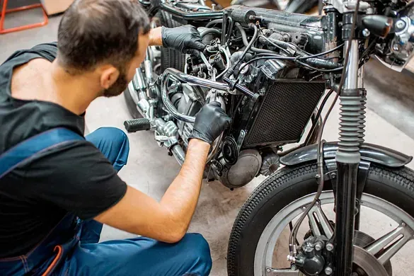 Un hombre está trabajando en una motocicleta en un garaje.