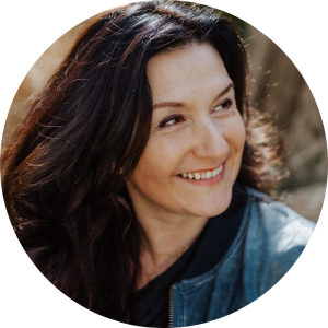 Frau mit dunklem, gewelltem Haar lächelt