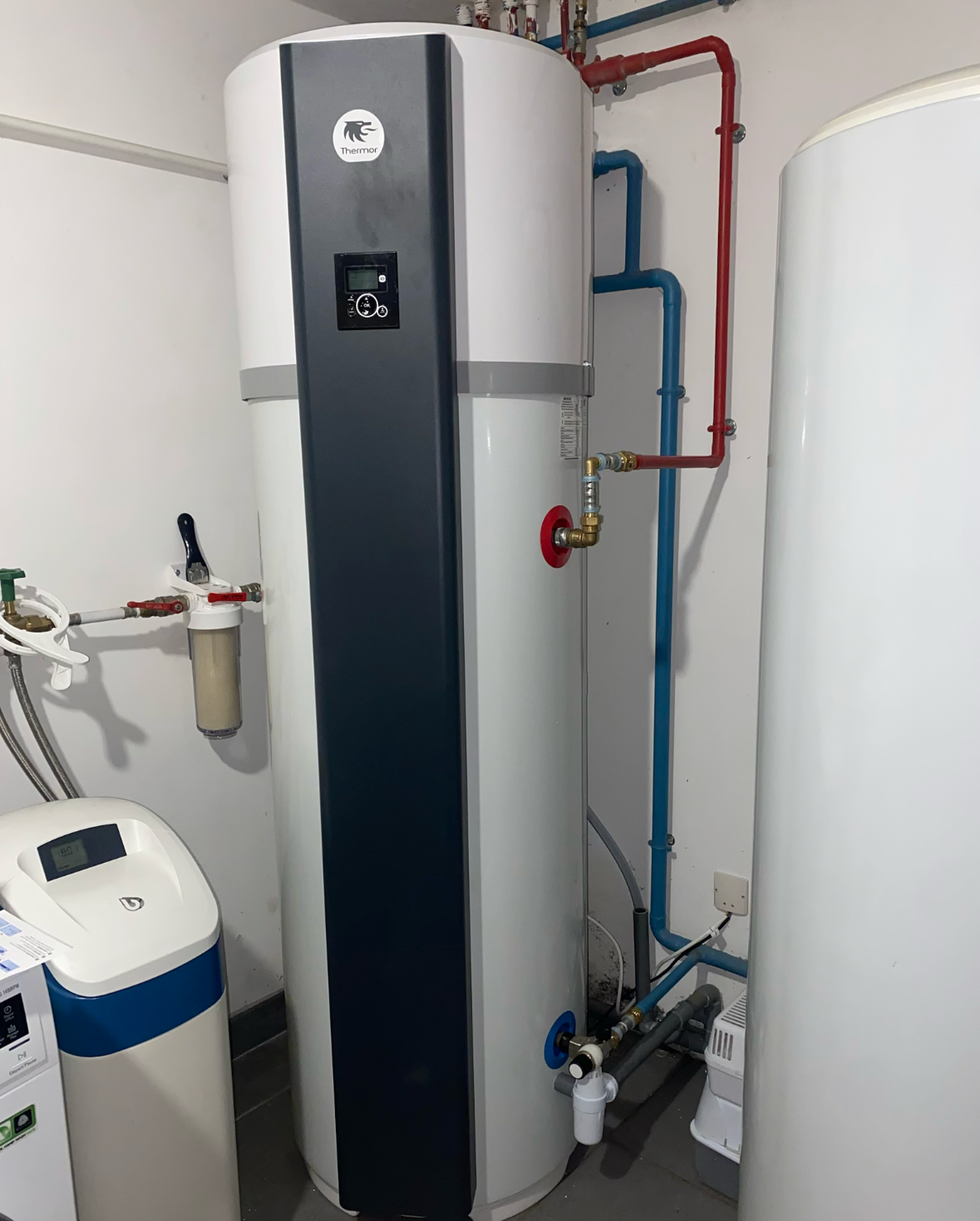 Un système de pompe à chaleur Mitsubishi Ecodan blanc installé dans un sous-sol.