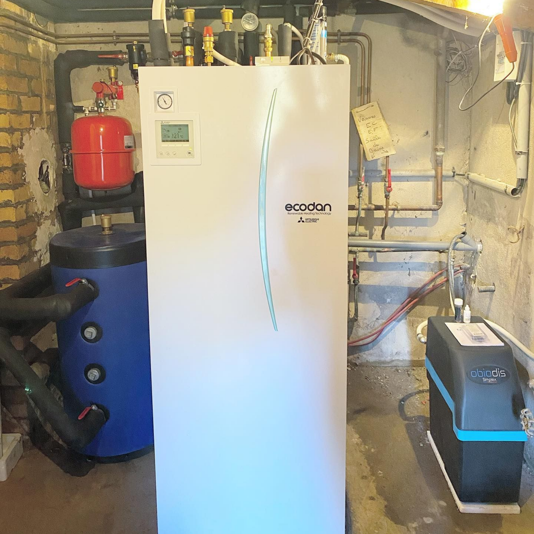 Un système de pompe à chaleur Mitsubishi Ecodan blanc installé dans un sous-sol.