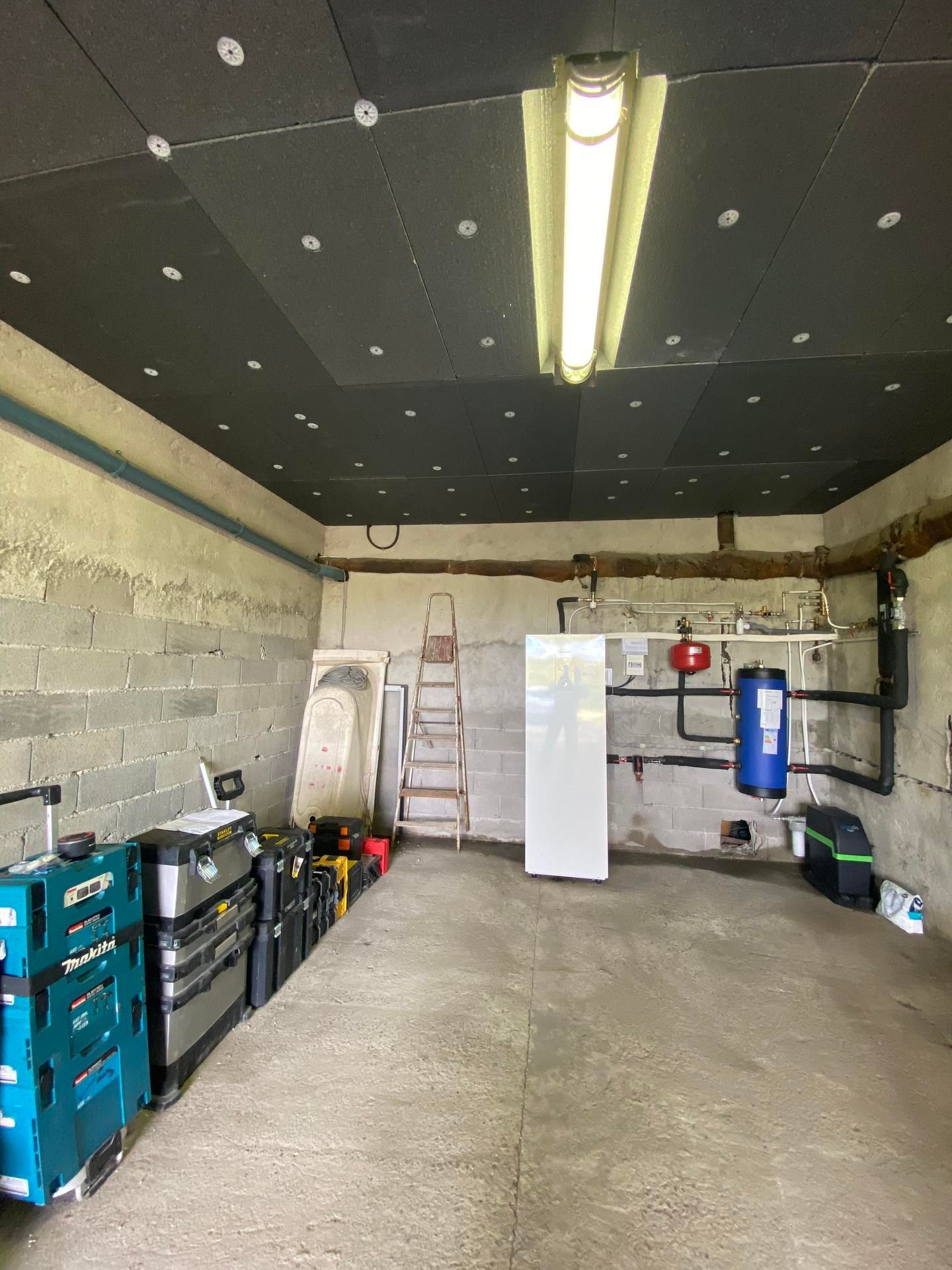 Une unité de pompe à chaleur Midea grise, installée à l'extérieur, repose sur des supports de montage noirs.