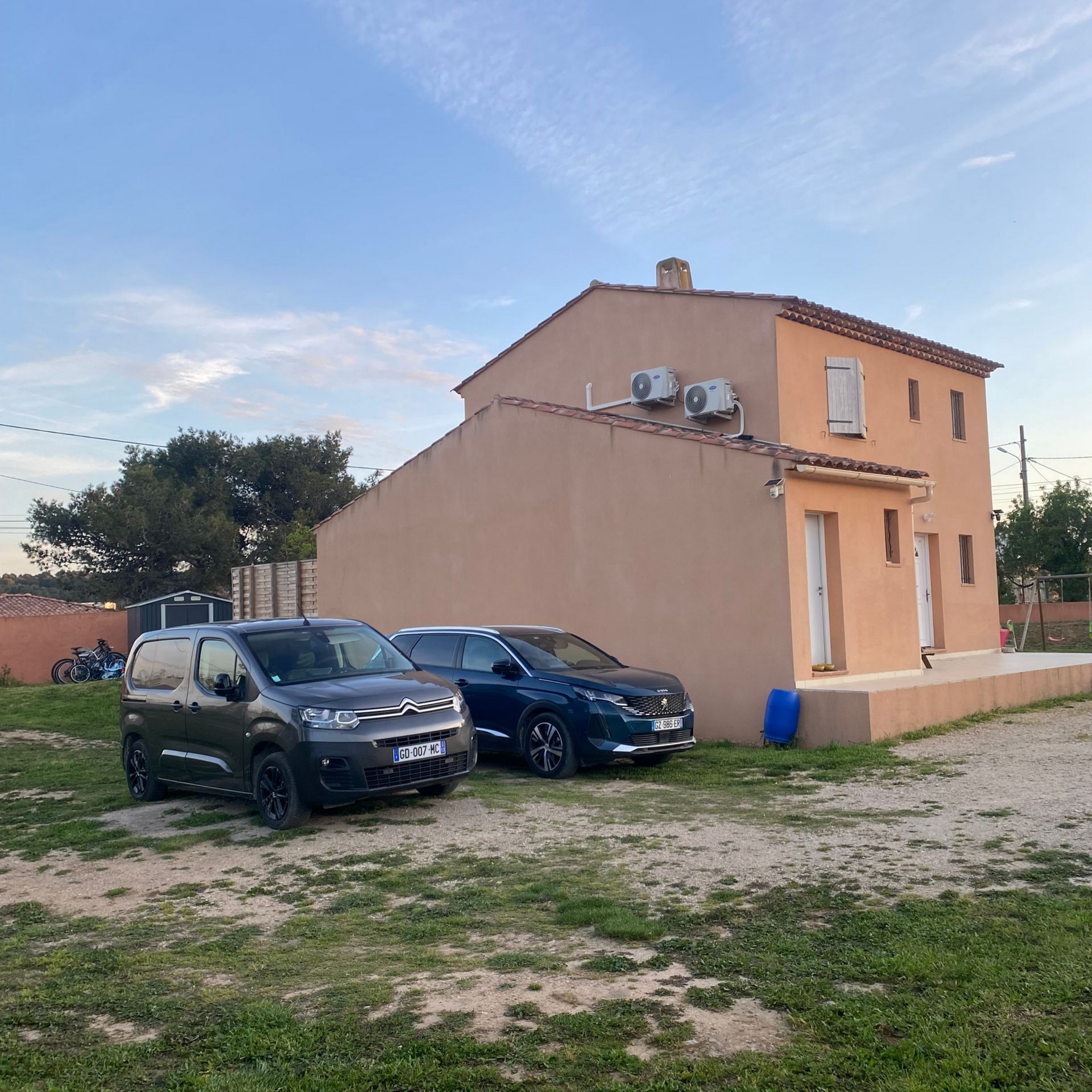 Une maison avec des unités de pompe à chaleur fixées à la façade.