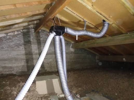 Grille d'aération circulaire blanche au plafond, comportant des anneaux concentriques.