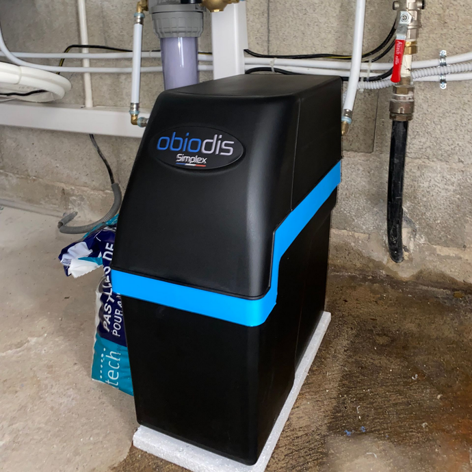 Adoucisseur d'eau Obiodis noir et bleu dans un sous-sol.
