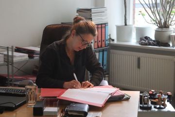 Zwei Menschen, am Tisch sitzend, planen oder beraten