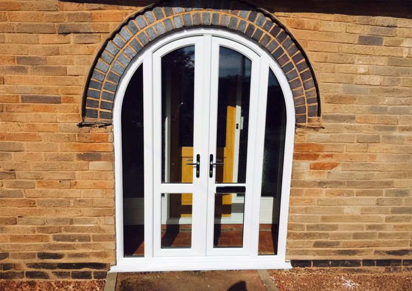 A brick building with a white arched door